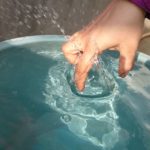 Mano in acqua con dita raggrinzite