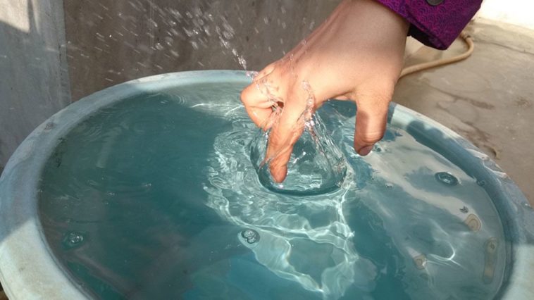 Mano in acqua con dita raggrinzite