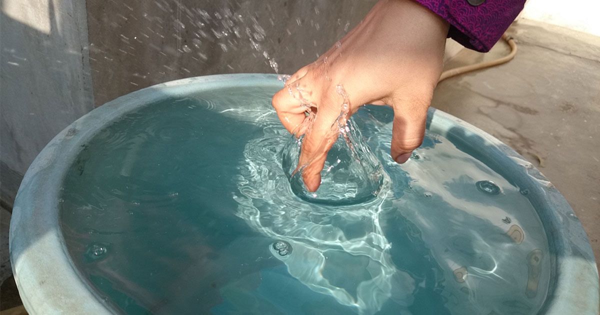 Mano in acqua con dita raggrinzite