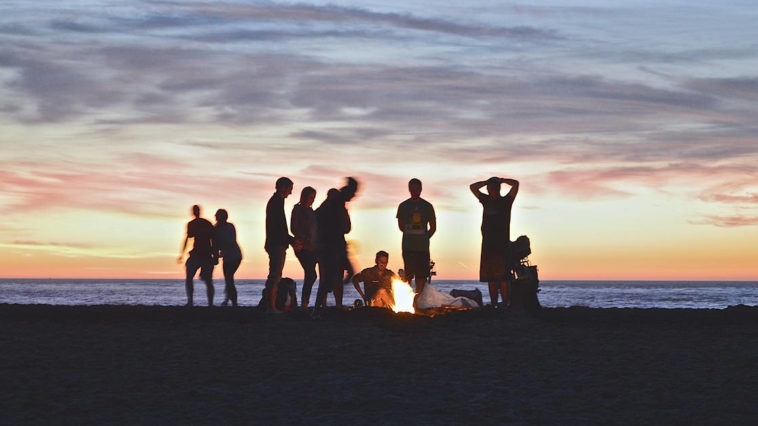 Gruppo di giovani amici attorno un falò per Ferragosto