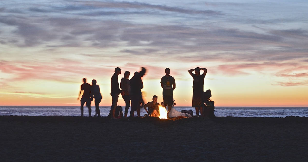Gruppo di giovani amici attorno un falò per Ferragosto