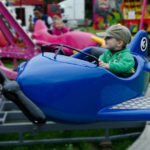Bambino su giostra guida aereo