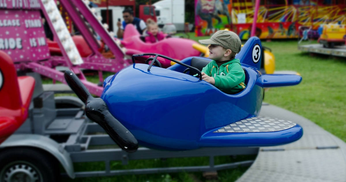 Bambino su giostra guida aereo