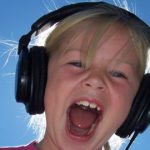 Bambina con cuffie che ascolta la sua voce