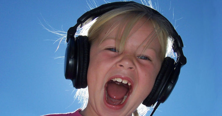 Bambina con cuffie che ascolta la sua voce