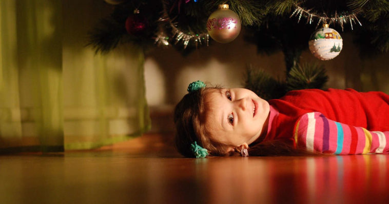 Una dolce bambina sotto l'albero di natale chissà quando si addobba