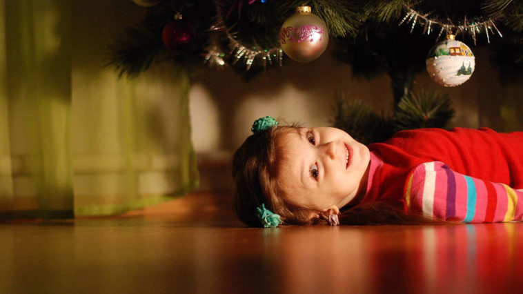 Una dolce bambina sotto l'albero di natale chissà quando si addobba