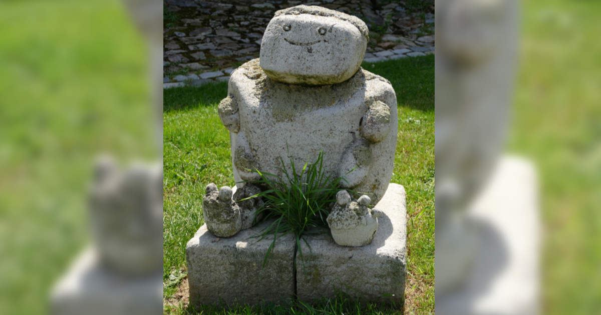 Statua in giardino che sembra avere peli pubici con ciuffo d'erba