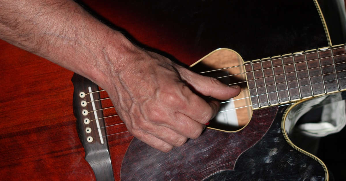 Chitarrista con mano con delle vene blu molto visibili