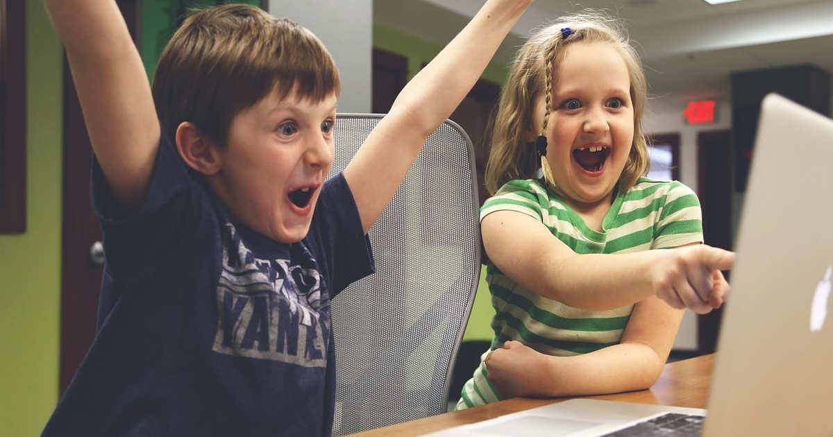 Dei bambini felici si divertono giocando al computer e il loro tempo è volato