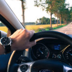 Uomo con orologio al polso guida un auto sul viaggio di ritorno che sembra più breve di quello dell'andata