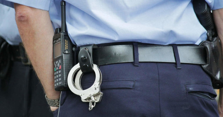 uno sbirro da dietro con delle manette