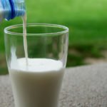 bicchiere di latte bianco versato da bottiglia