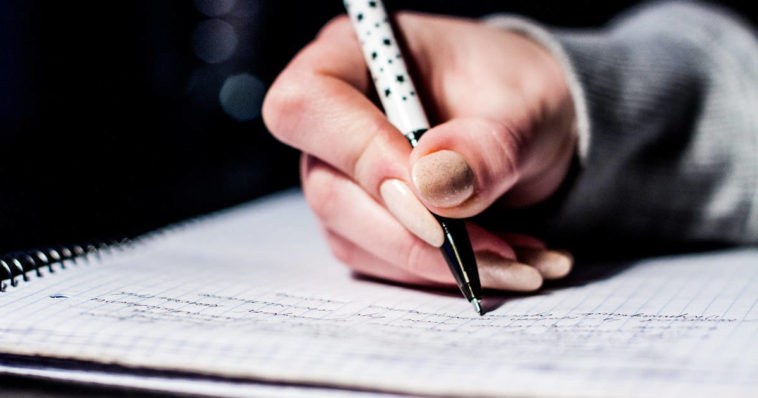 Mano che scrive su quaderno
