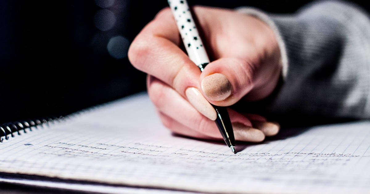 Mano che scrive su quaderno