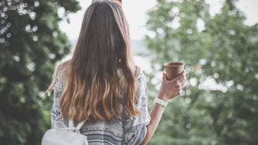Ragazza viaggia e beve nel verde