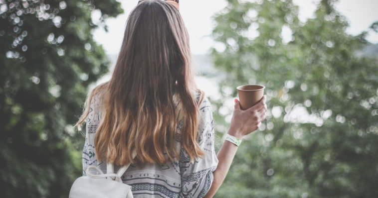 Ragazza viaggia e beve nel verde