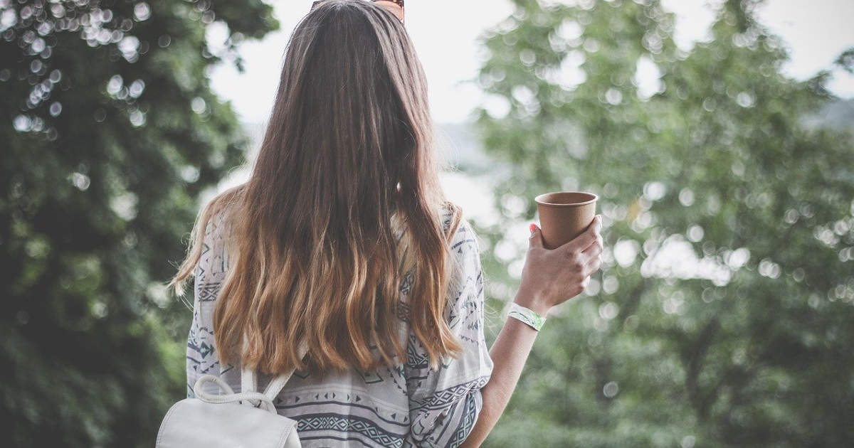 Ragazza viaggia e beve nel verde