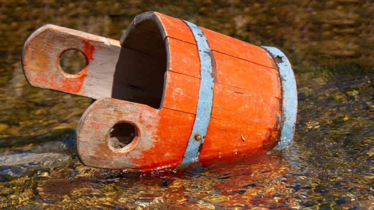 Un secchio di legno in pozza d'acqua